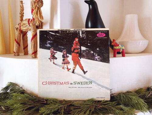 Photograph of Åke Jelving's 'Christmas in Sweden' record album sitting on a traditional New Mexico fireplace surrounded by Swedish Christmas decorations